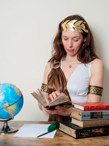 Adrianna consultant un ouvrage juridique entourée de livres de droit et d’un globe terrestre.